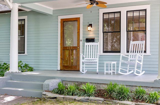 A front porch with rocking chairs and a path leading to the door