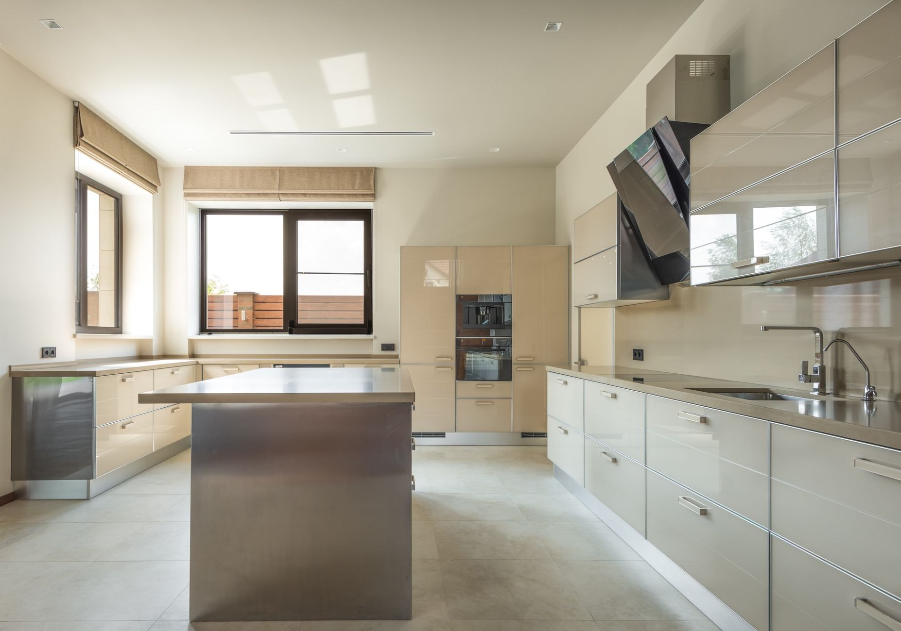A bright kitchen with pale cabinets and daylight from a side window