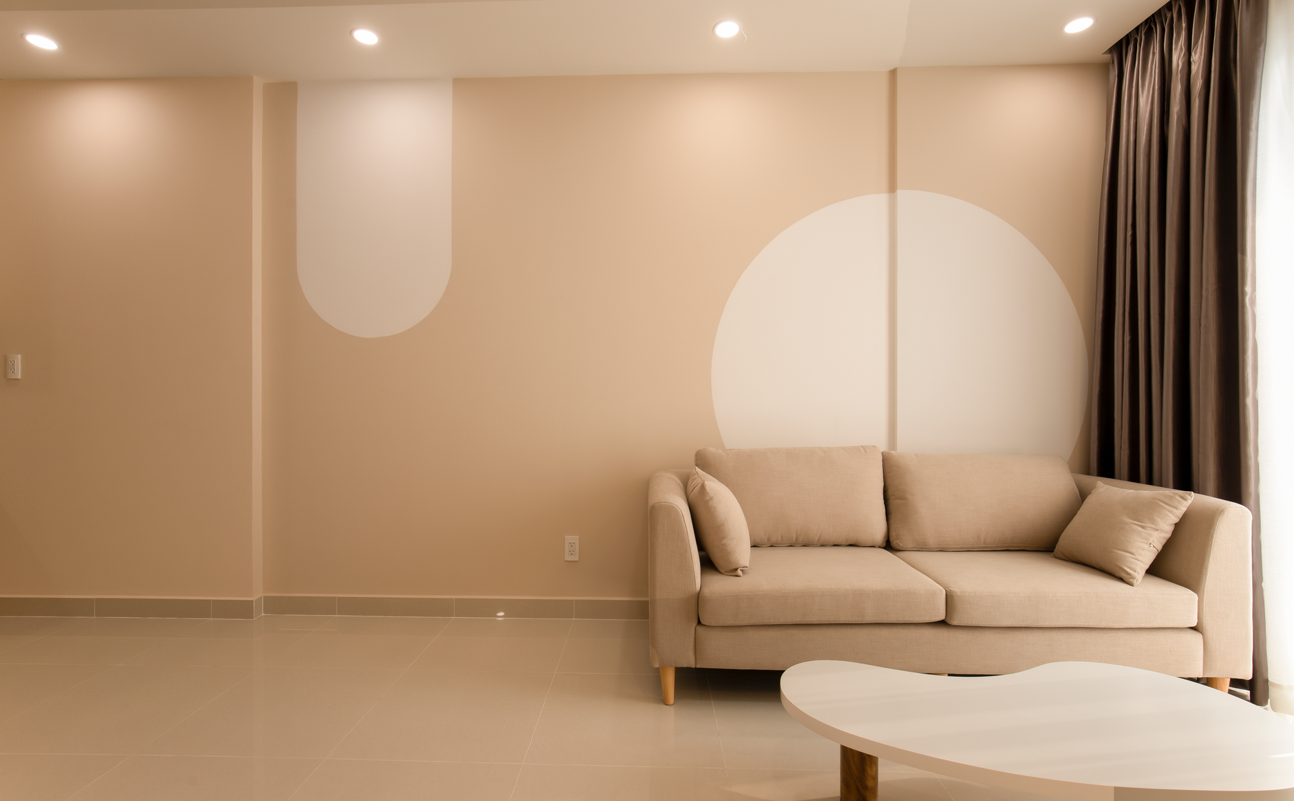 A cozy minimalist living room featuring a beige sofa, modern decor, and neutral tones for an inviting atmosphere, illustrating How to Arrange Furniture So a Room Feels Calm