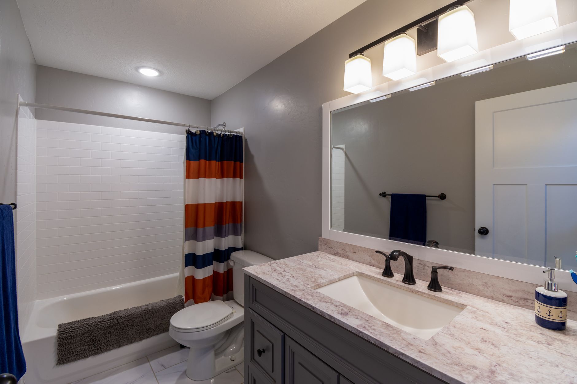 Bright and minimalist bathroom with a modern vanity and colorful shower curtain, illustrating What Does Feng Shui Say About a Bathroom Door