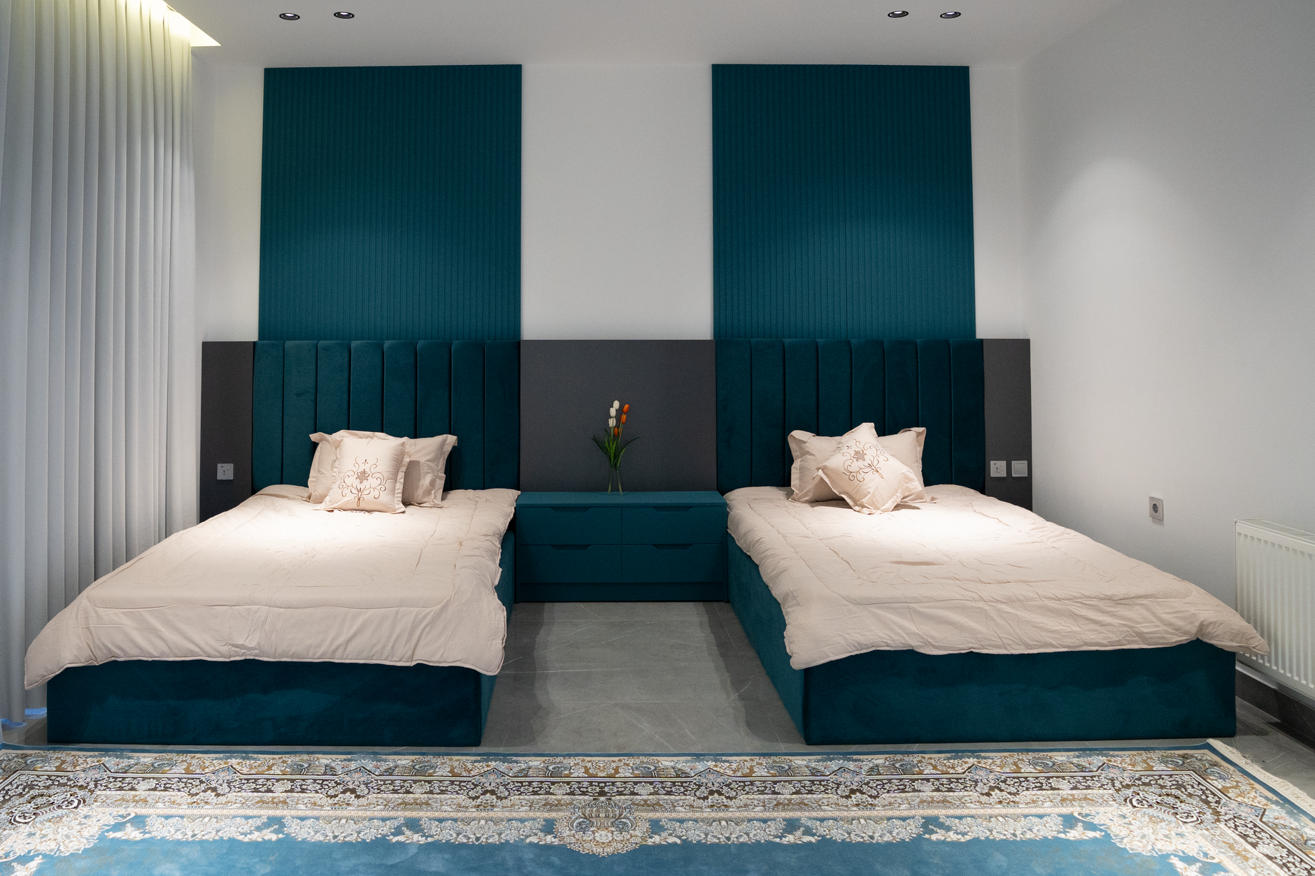 Modern twin bedroom with teal accents, stylish headboards, and cozy decor, illustrating What Feng Shui Says About a Bed That Faces the Door
