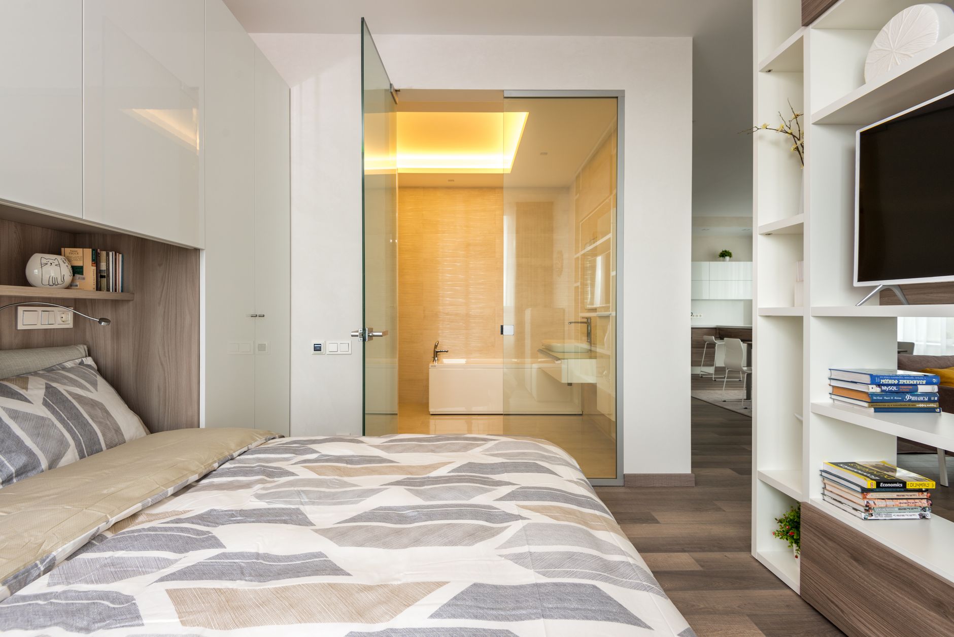 Interior of contemporary bedroom with white built in wardrobe and shelves behind bed and TV shelf against, illustrating Bedroom Above a Garage: What Feng Shui Actually Says