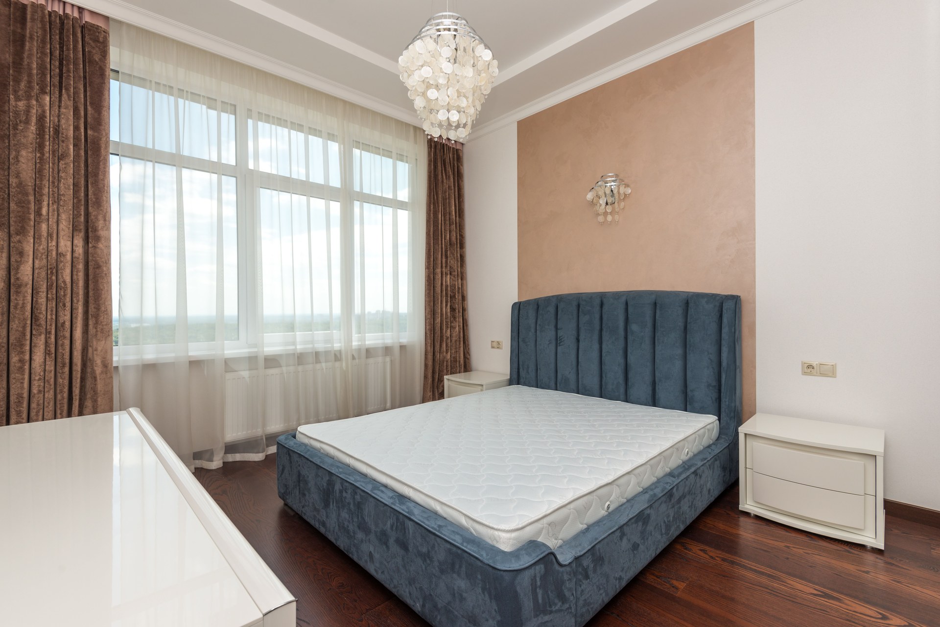 Bedroom featuring a blue velvet bed, large windows, and chic decor