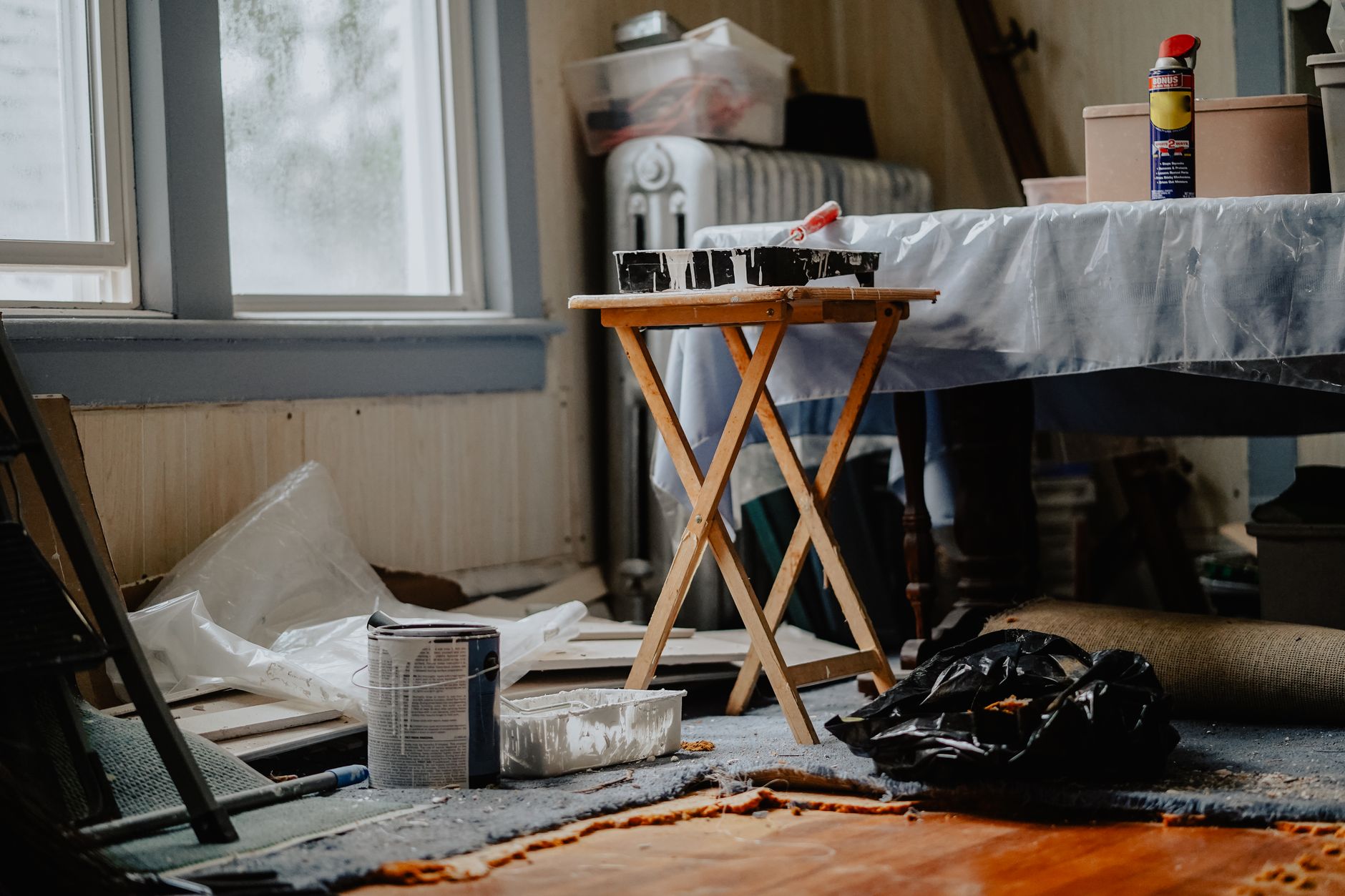 Interior view of a home renovation with paint supplies on a wooden table, illustrating Why Is 'Buy This Lucky Object' Bad Feng Shui Advice