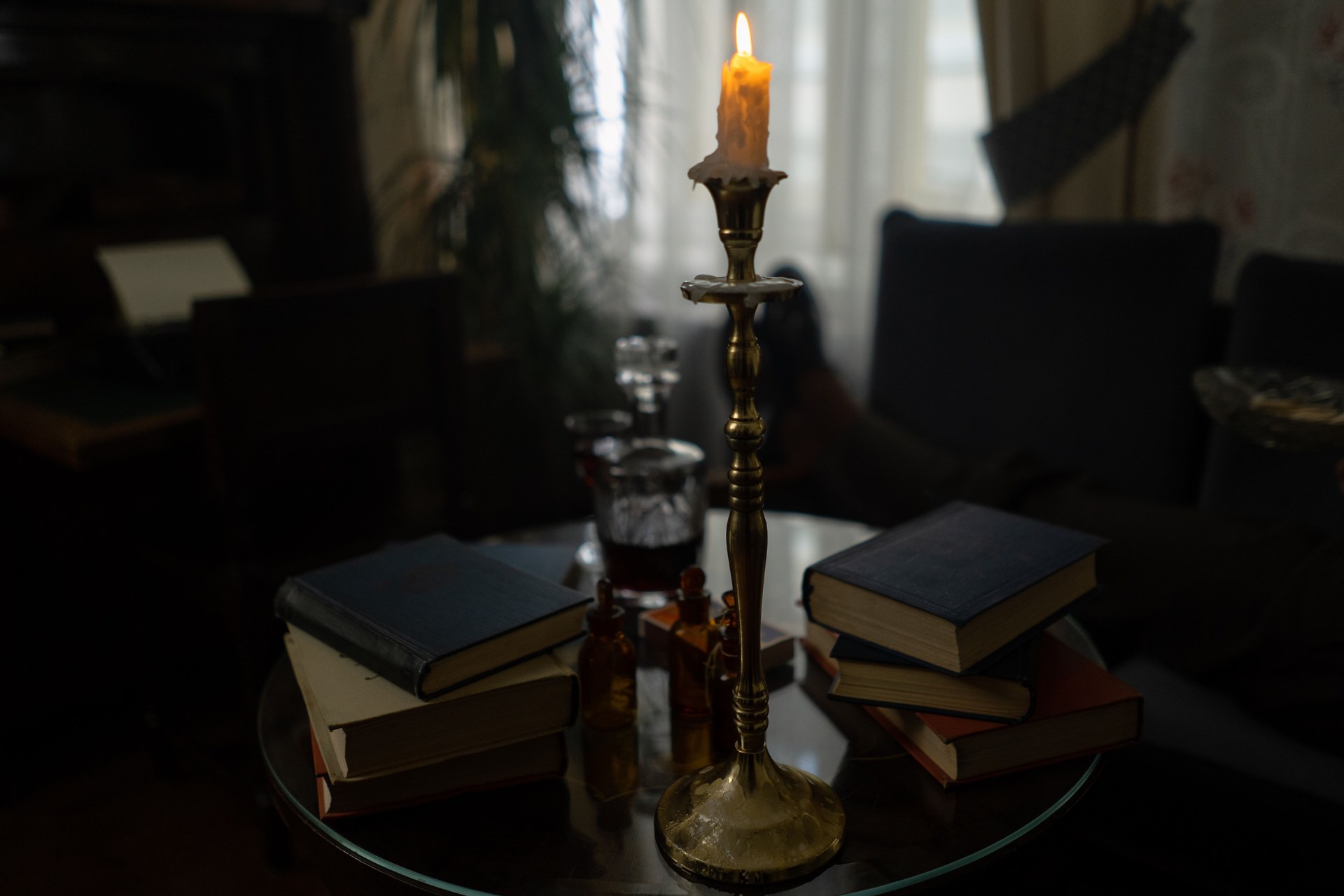 Indoor scene with stacked books and a candle, creating a warm and inviting atmosphere