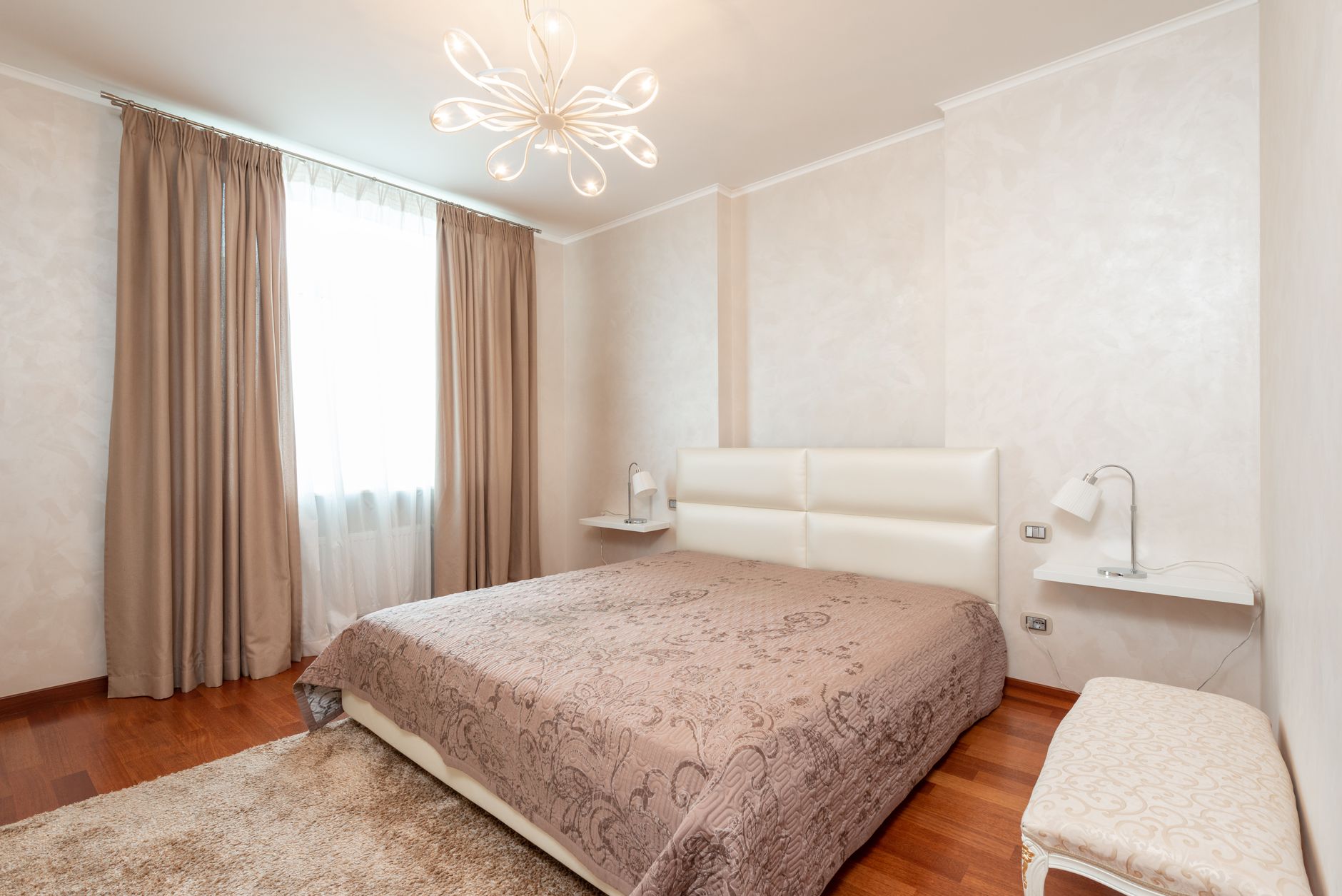 Comfortable bed with coverlet in cozy bedroom decorated with chandelier and lamps in classic styled apartment, illustrating What Does Feng Shui Say About a Children's Bedroom