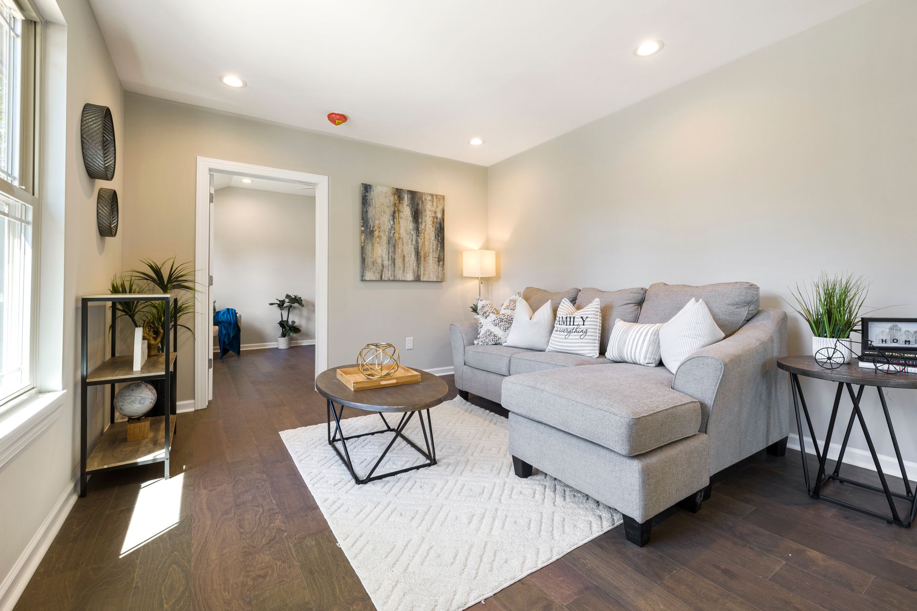 A beautifully designed living room featuring a gray sofa, chic decor, and bright natural light, illustrating What Does Feng Shui Say About a Corner Plot