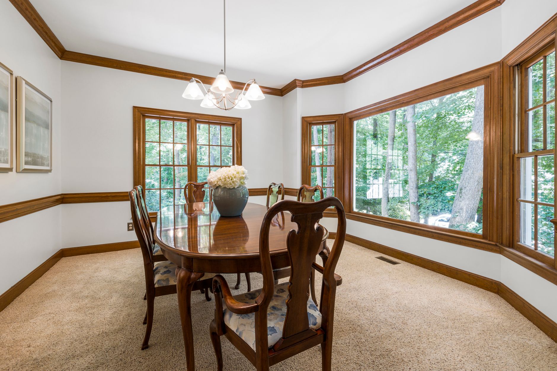 Traditional dining room interior featuring wooden furniture and large picture windows, illustrating Where Should a Dining Room Mirror Go? A Feng Shui Guide