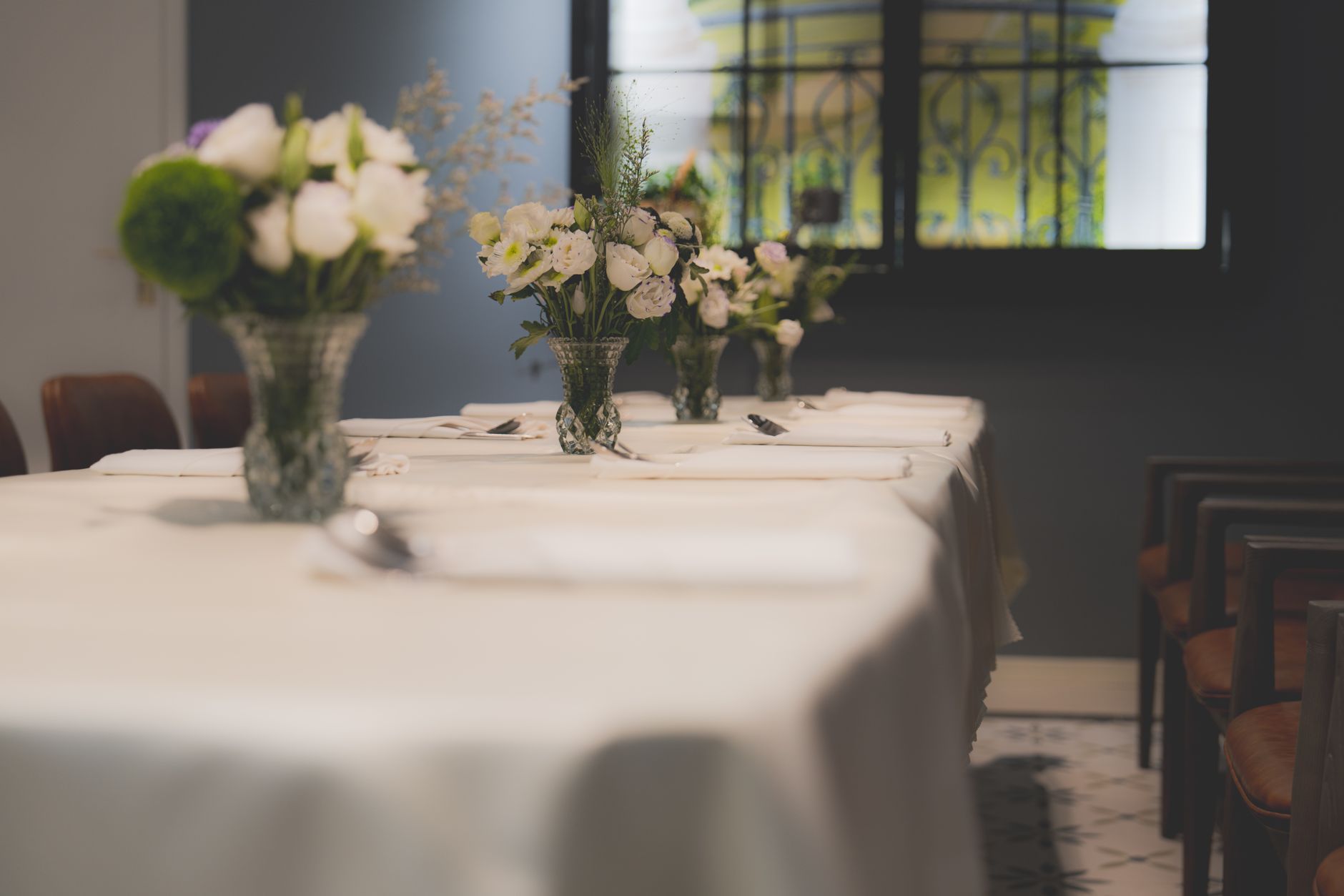 A luxurious dining table setup featuring elegant white tablecloths and beautiful floral arrangements in a sophisticated hotel interior, illustrating What Does Feng Shui Say About a