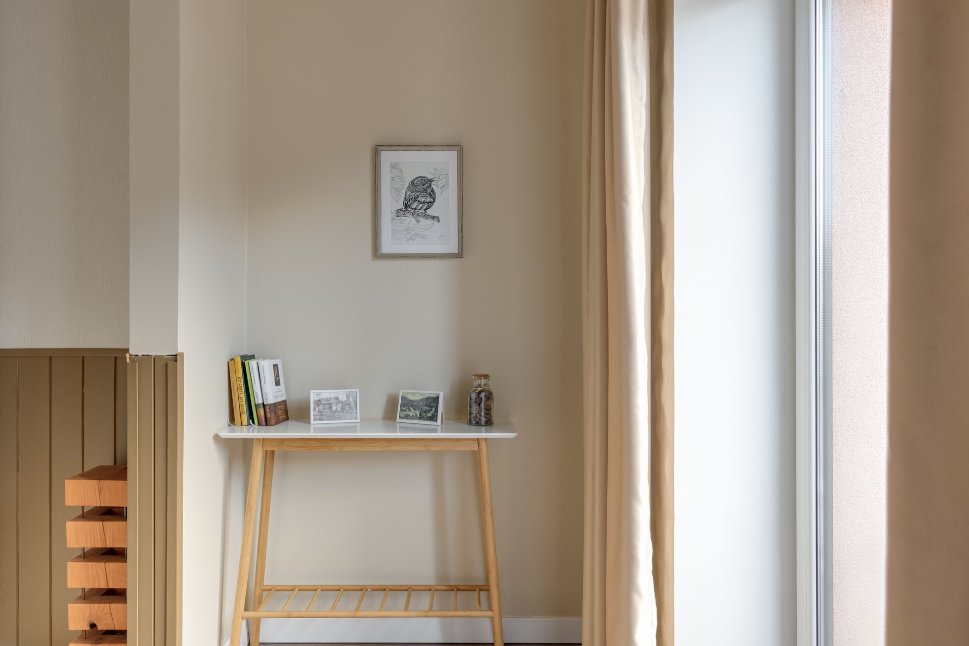 A minimalist room with a wooden table, books, and framed art, creating a serene space