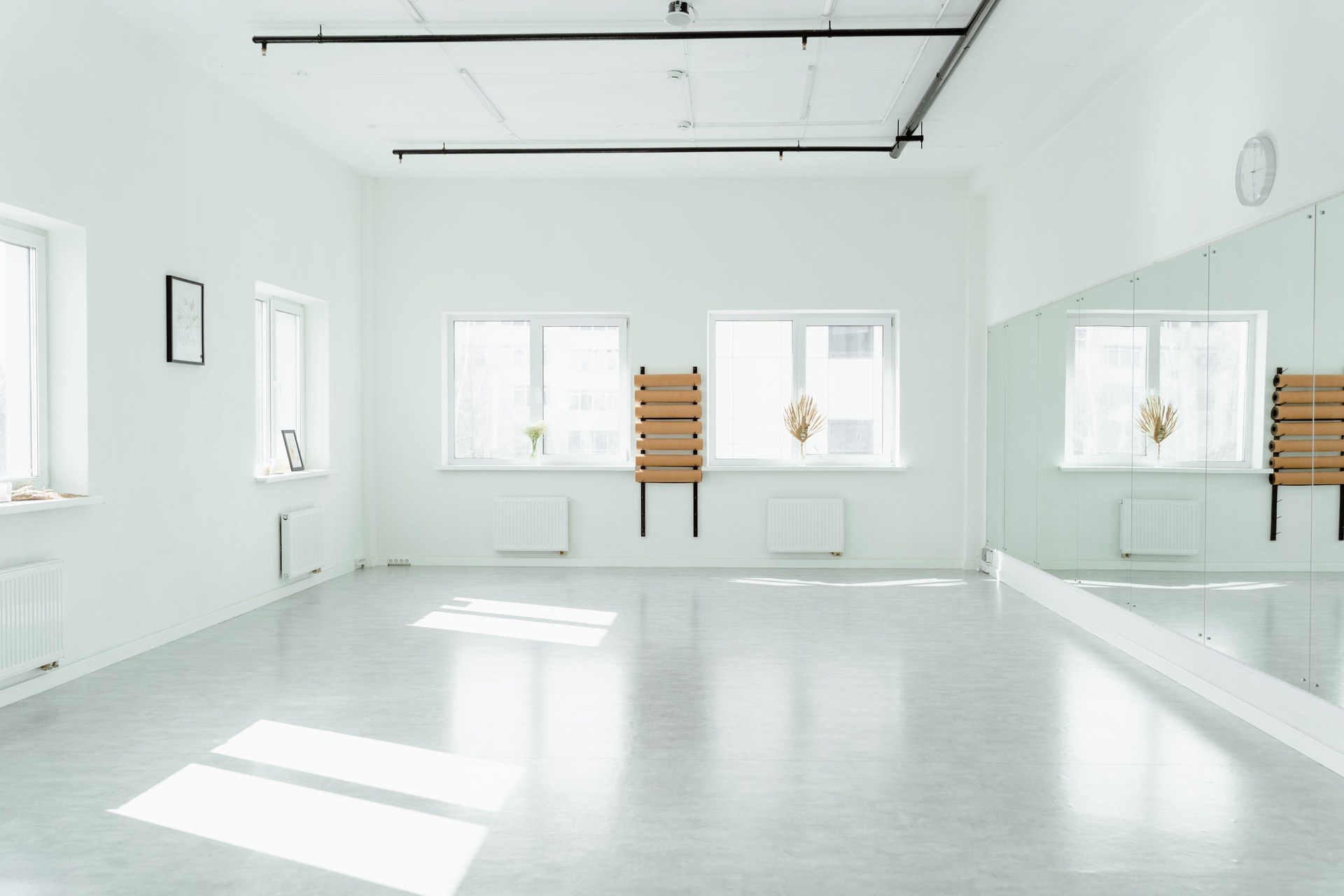 Bright and empty dance studio with mirrors and sunlight streaming in