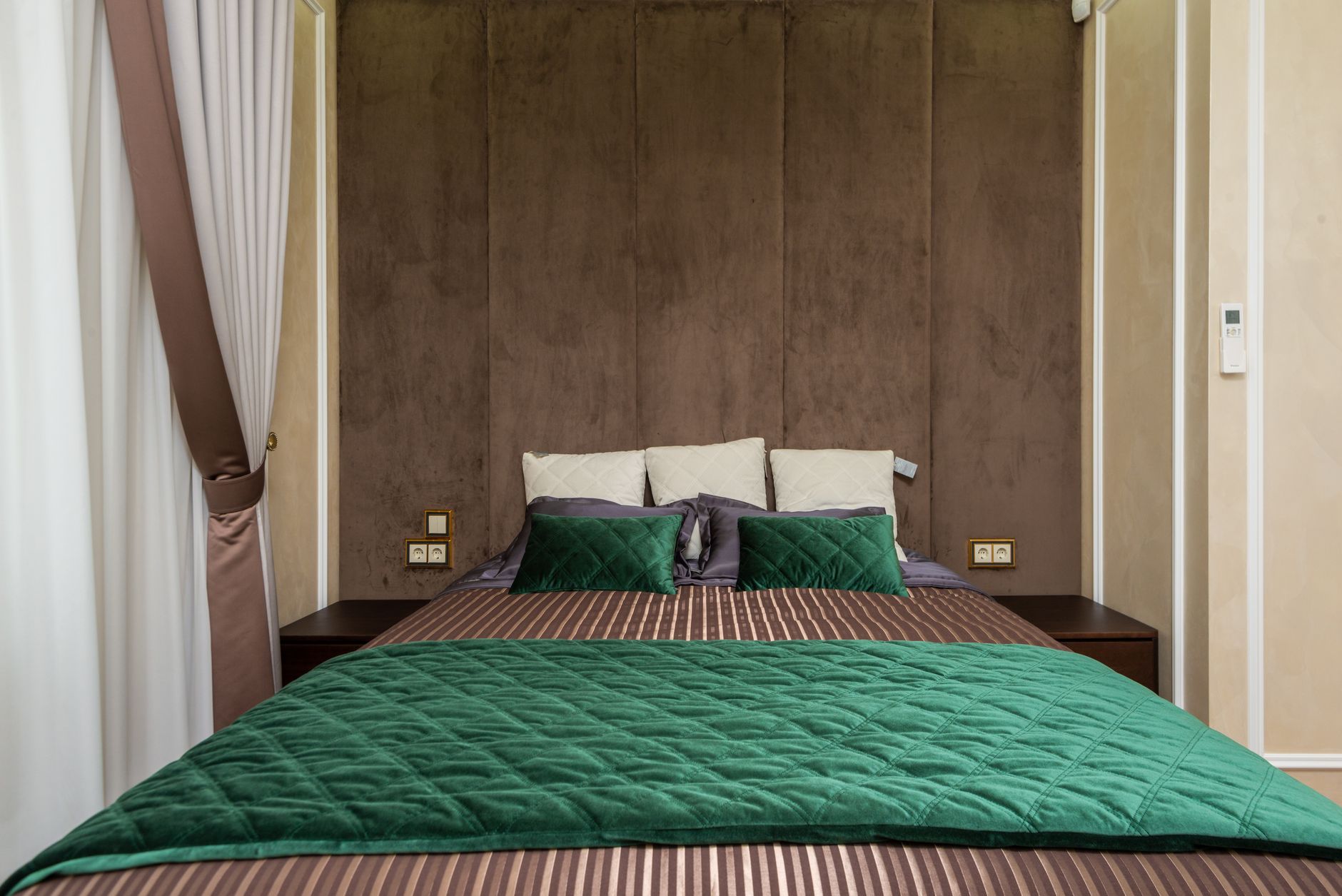 Cozy modern bedroom with green bedding and soft lighting. Ideal for contemporary design inspiration, illustrating What Does Feng Shui Say About Mirrors in a Bedroom