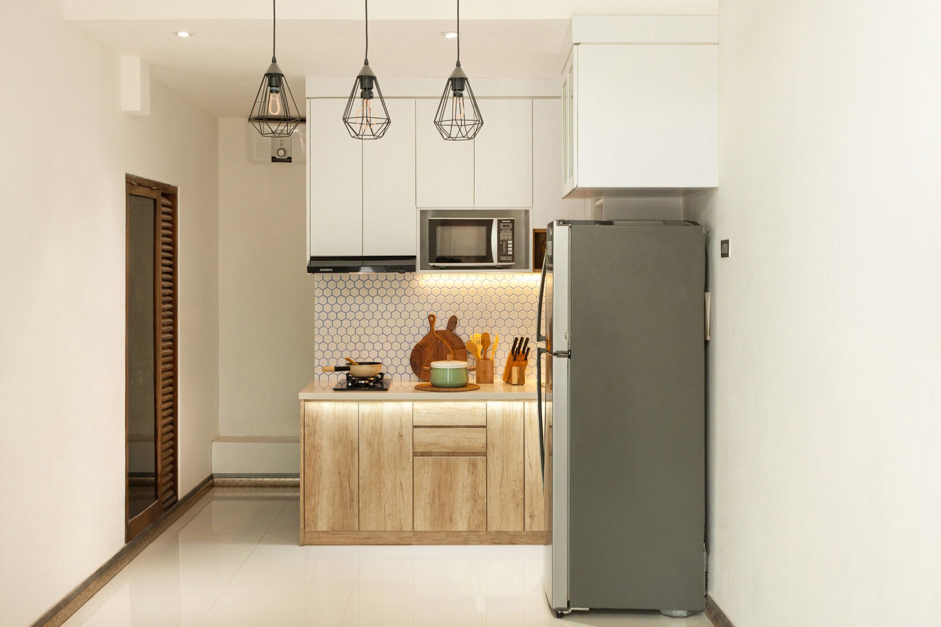 Stylish minimalist kitchen interior with wooden cabinets and sleek appliances, illustrating How to Apply Feng Shui in a Studio Apartment