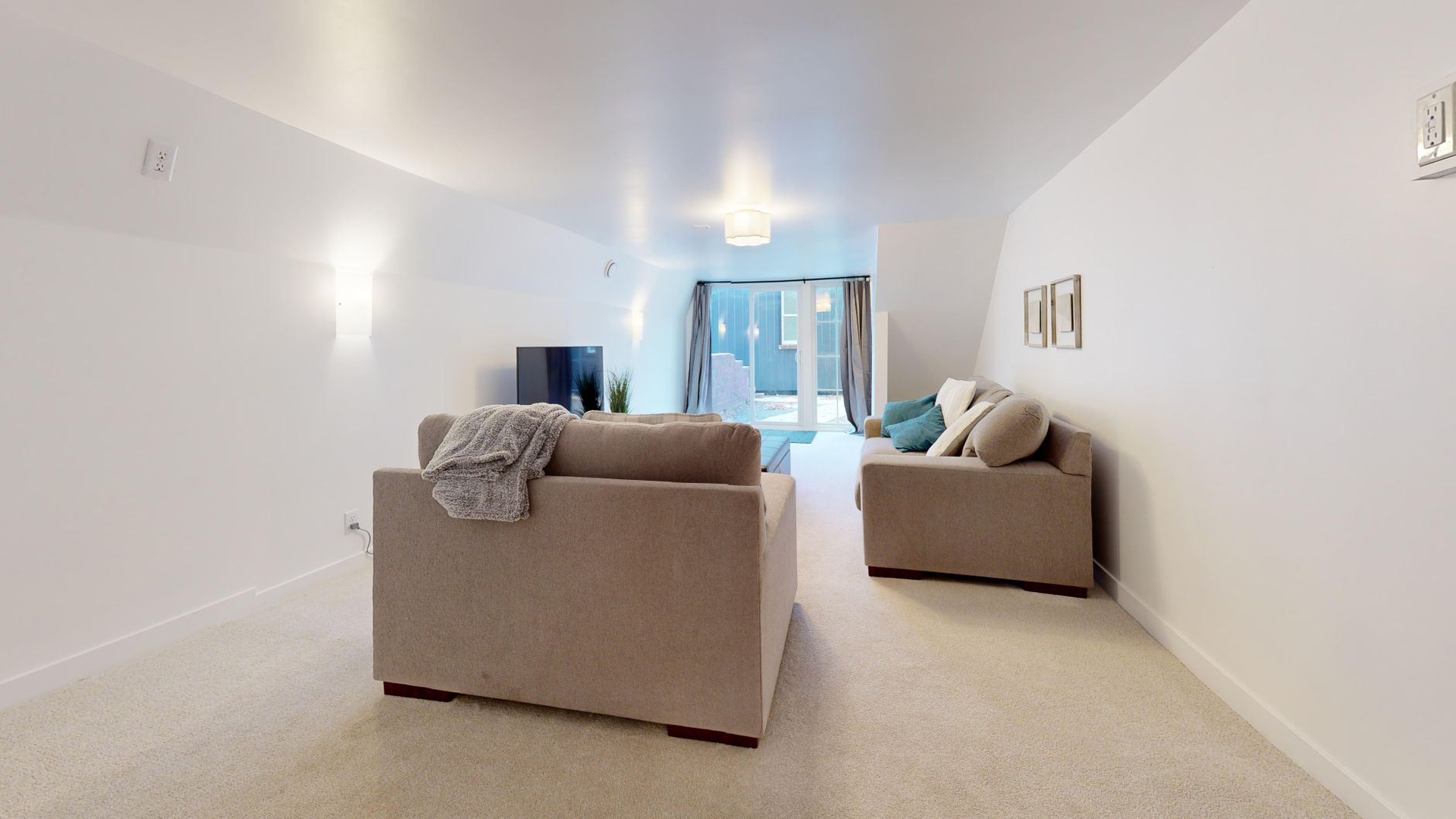 Spacious minimalist living room with neutral decor and natural light, illustrating What Does Feng Shui Say About a TV in the Living Room