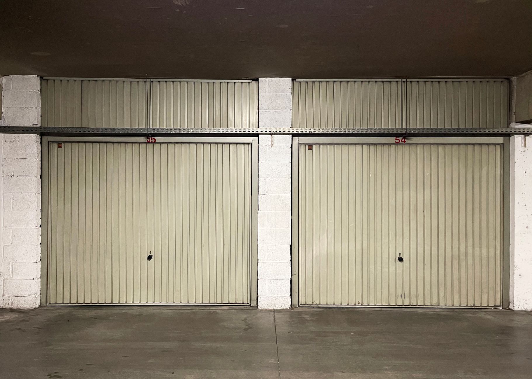 Two closed garage doors inside an empty warehouse space, illustrating Garage Facing the Street: What Feng Shui Actually Says