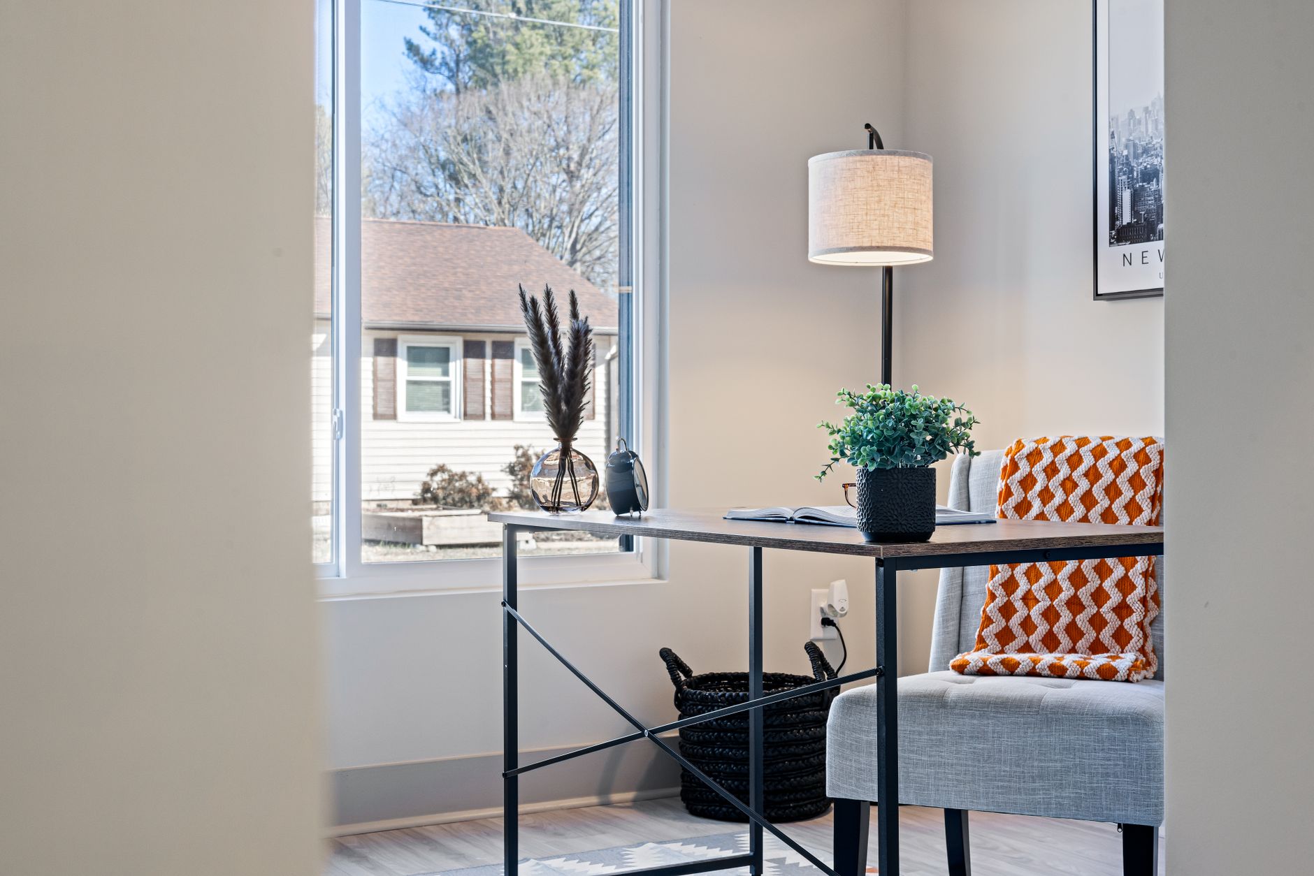 Bright modern home office with a minimalist desk, lamp, and cozy blanket by the window, illustrating Where Should a Home Office Desk Face? Feng Shui Guide