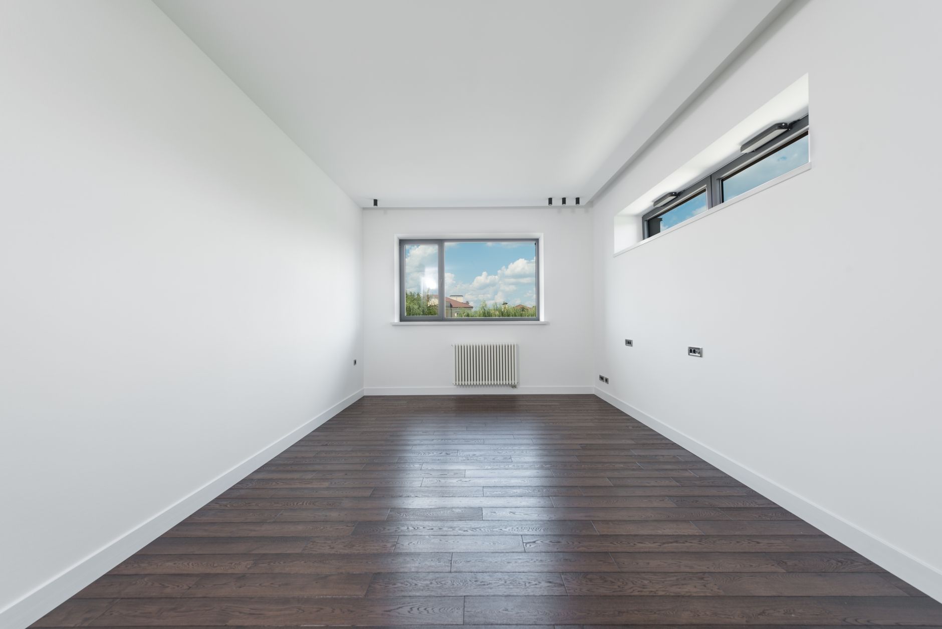 Interior of empty spacious room with white walls and brawn parquet floor in daylight, illustrating Home Viewing Feng Shui Checklist: What to Look At