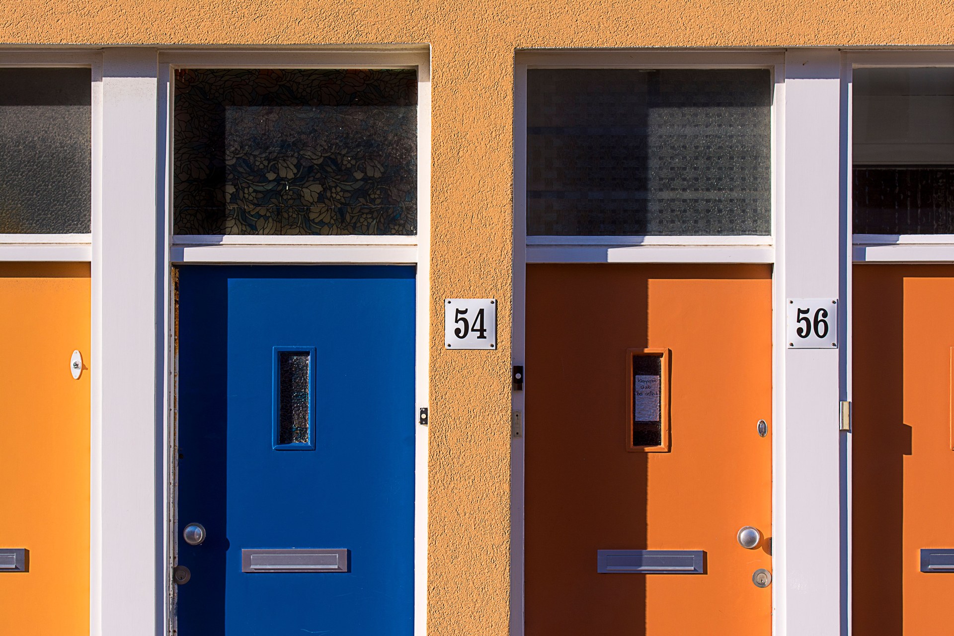 Brightly colored doors with numbers 54 and 56 on a modern building facade