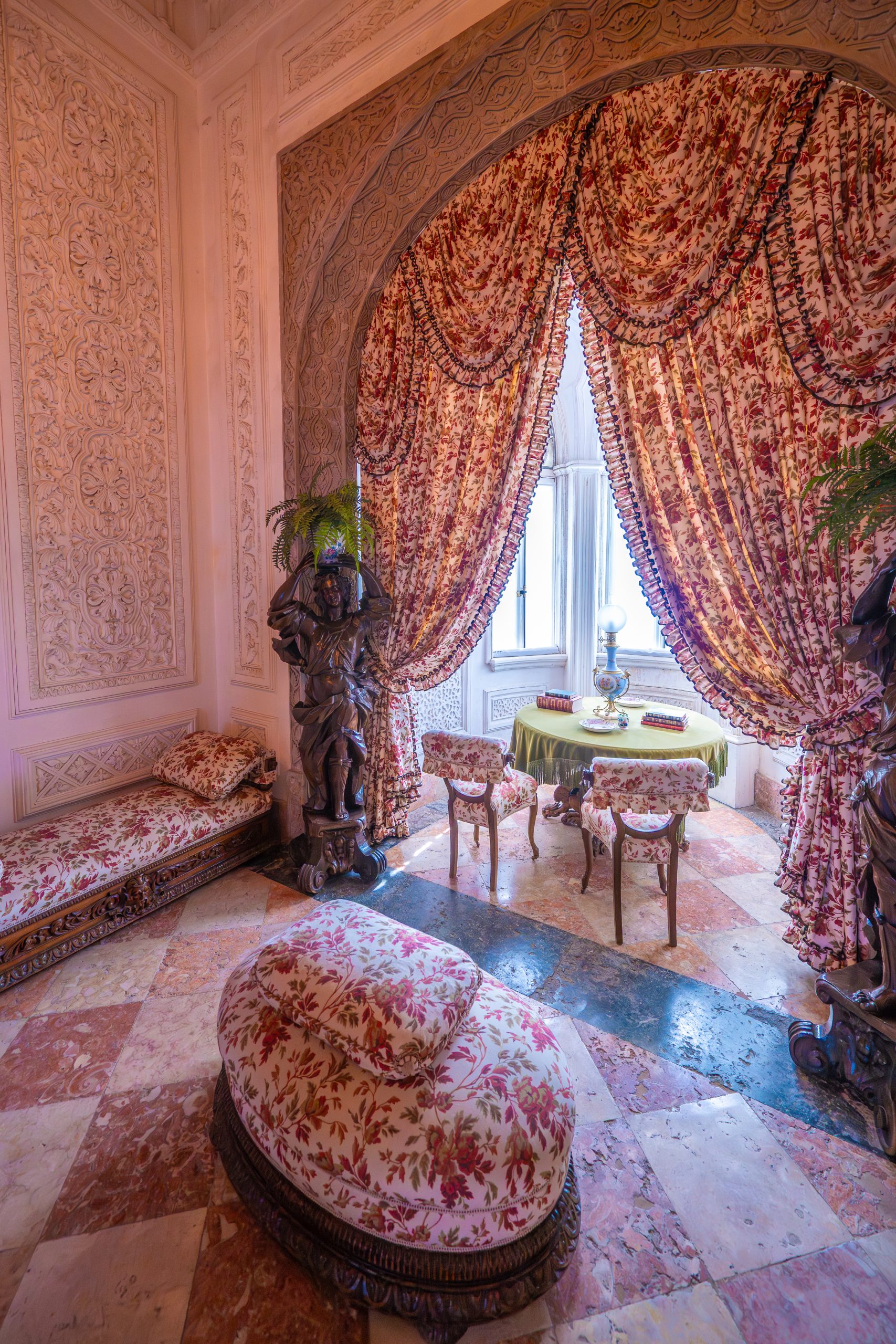 Elegant antique room interior with floral curtains and a sunlit window, illustrating How Should Artificial Lighting Be Layered in a Room