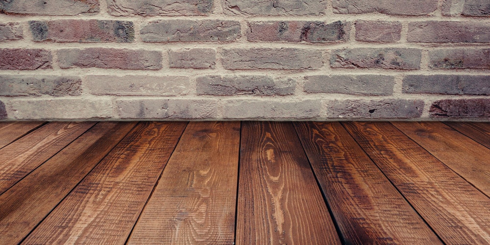 Vintage brick wall background complemented by a rustic wooden floor