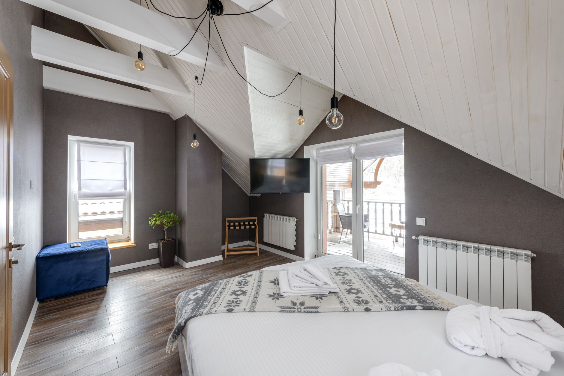 A modern bedroom with a large bed, balcony access, and stylish lighting, illustrating The Most Common Feng Shui Mistake in a Bedroom