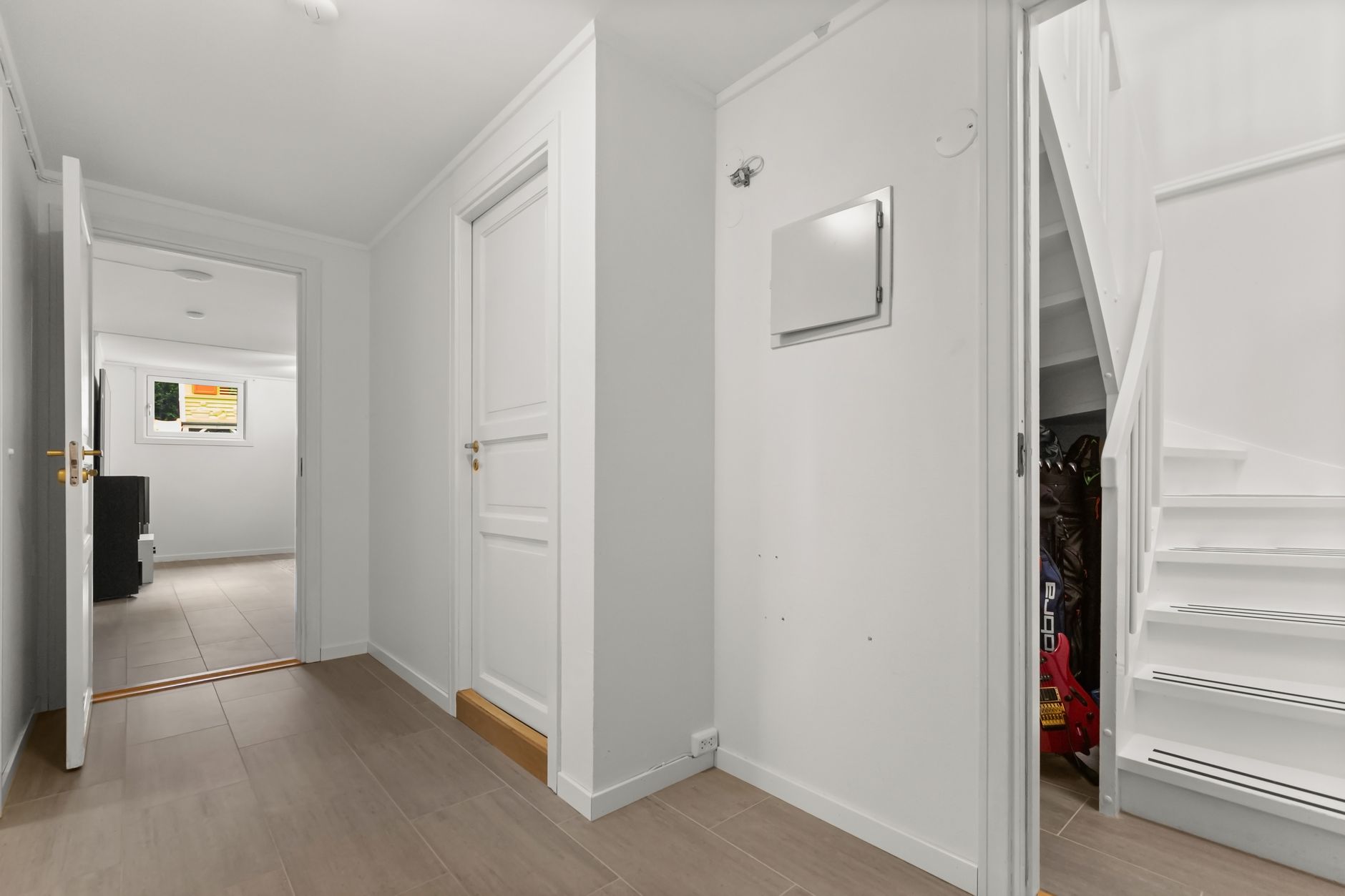 Bright and modern white hallway with stairs and open doors, showcasing minimalist interior design, illustrating Narrow Hallway Feng Shui: How Should It Be Handled