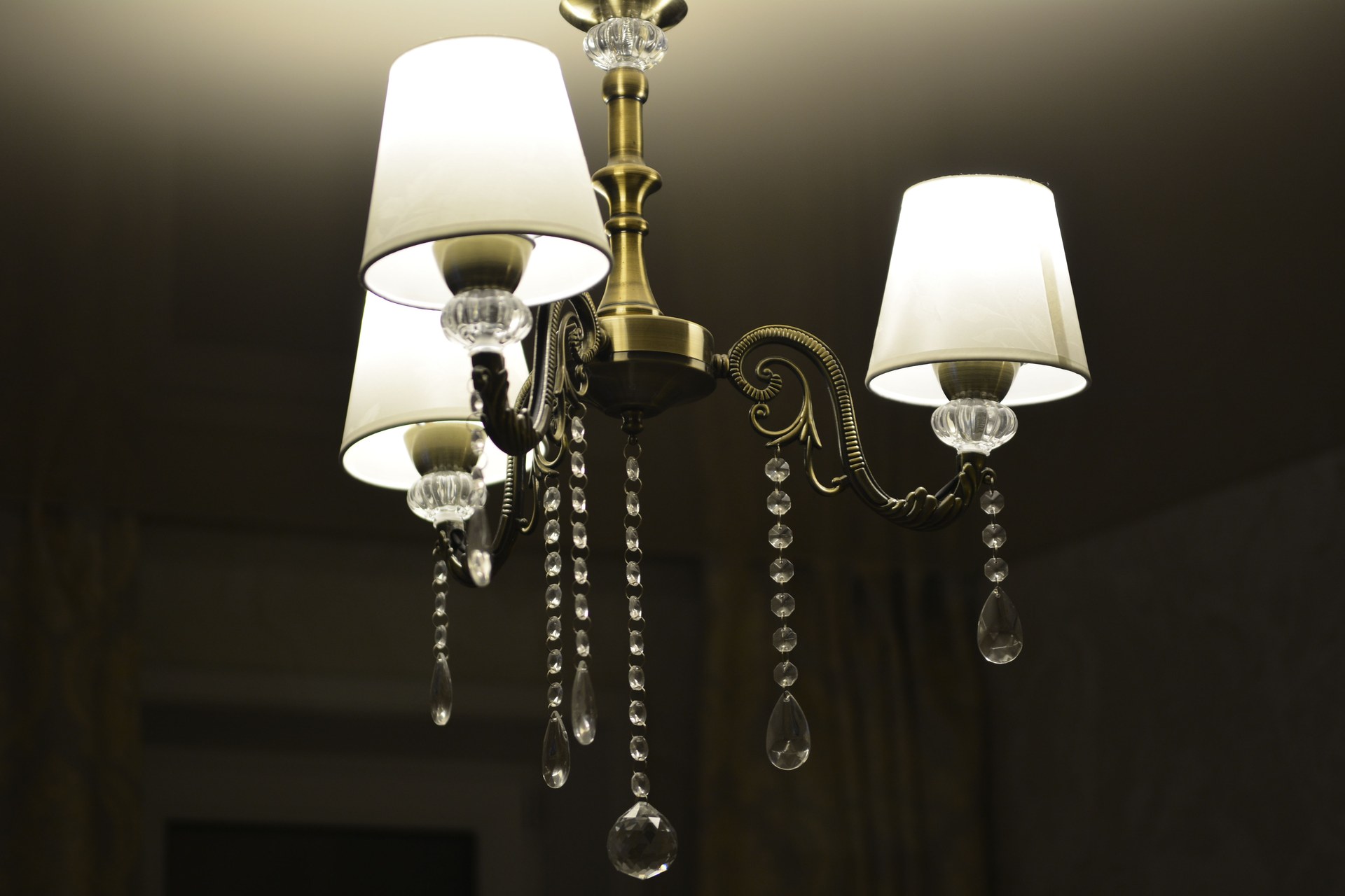 Close-up of an illuminated brass chandelier with crystal accents, ideal for interior decor themes