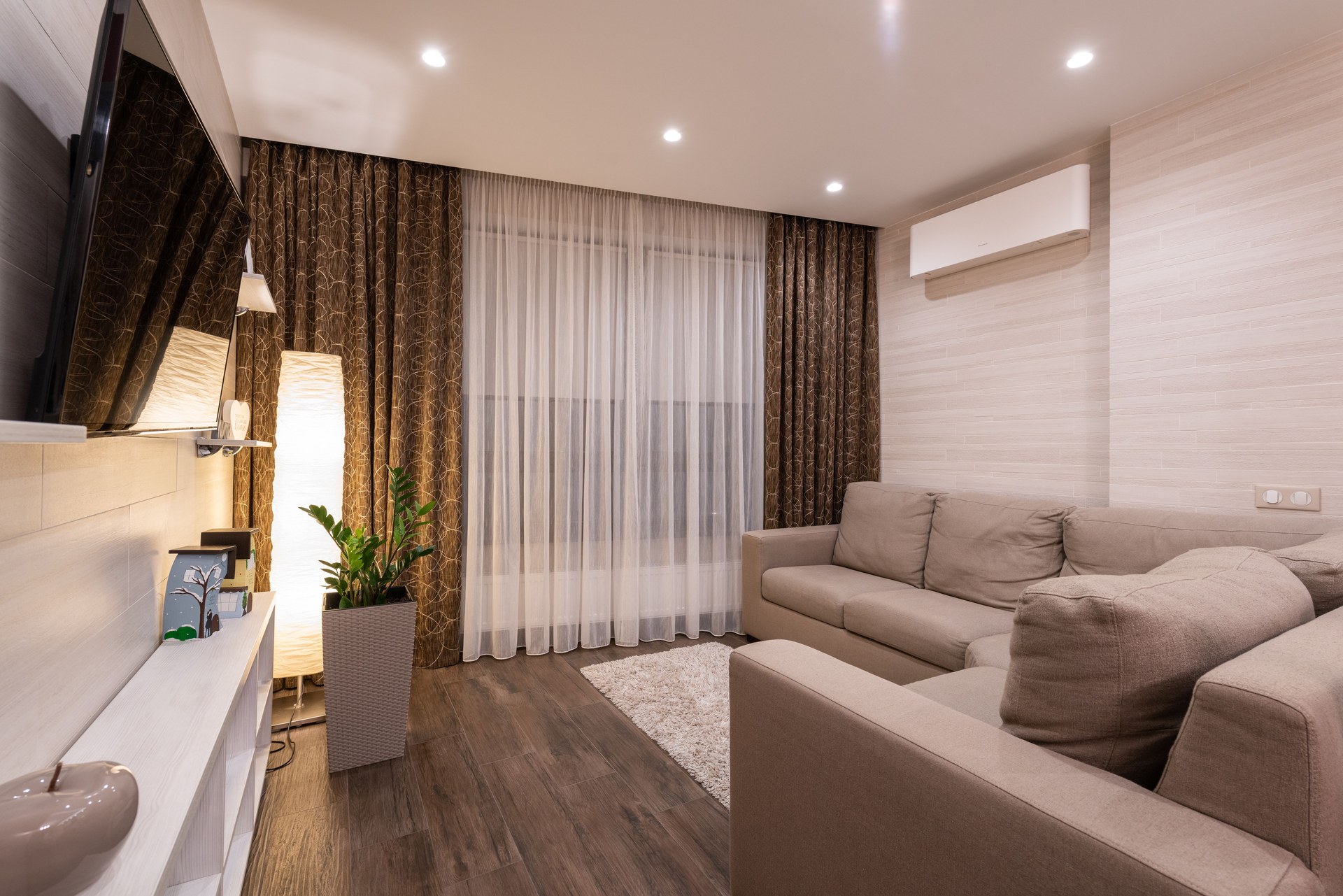 And cozy living room featuring a sofa, wooden flooring, and soft lighting