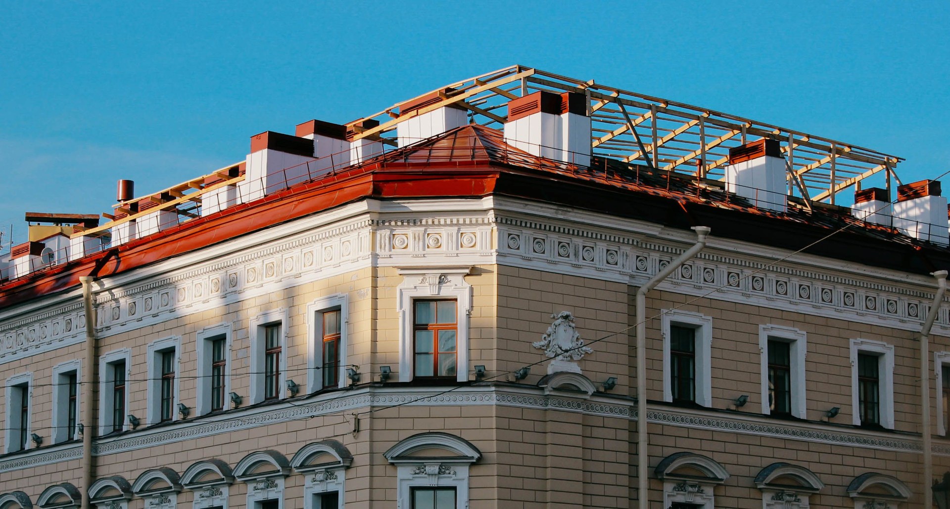 Detailed view of an ornate classical architecture building facade with intricate designs and a red roof