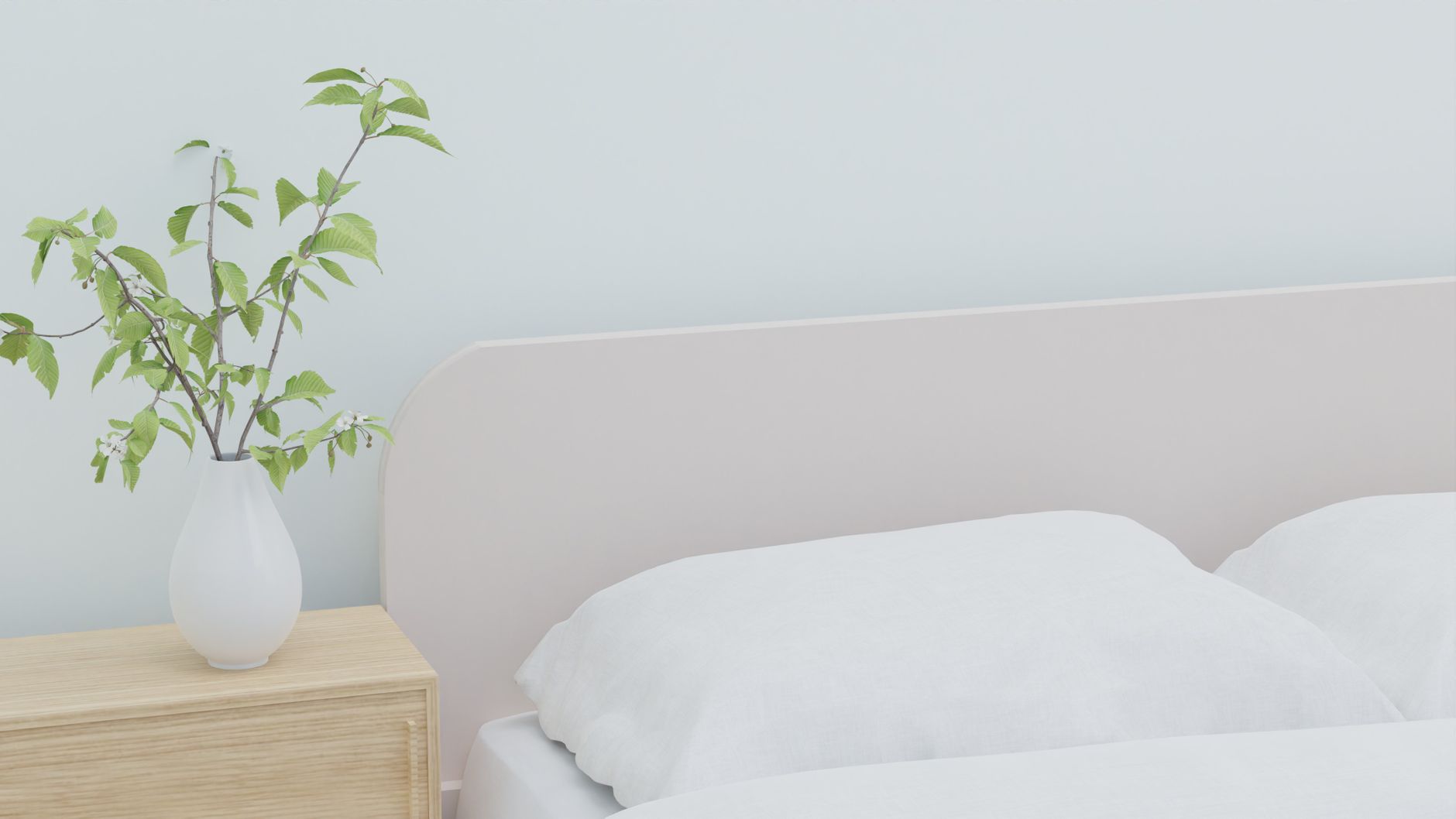 Soft and serene bedroom featuring white bedding and a vase with greenery on a wooden nightstand, illustrating What Feng Shui Says About Storing Things Under the Bed