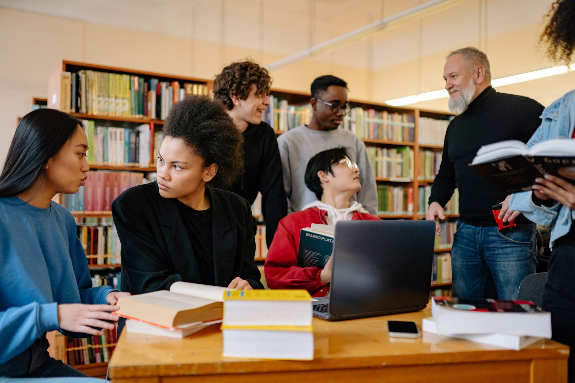 A diverse group of students studying together at a university library, engaged in discussion, illustrating How Should a Study or Work Corner Be Arranged