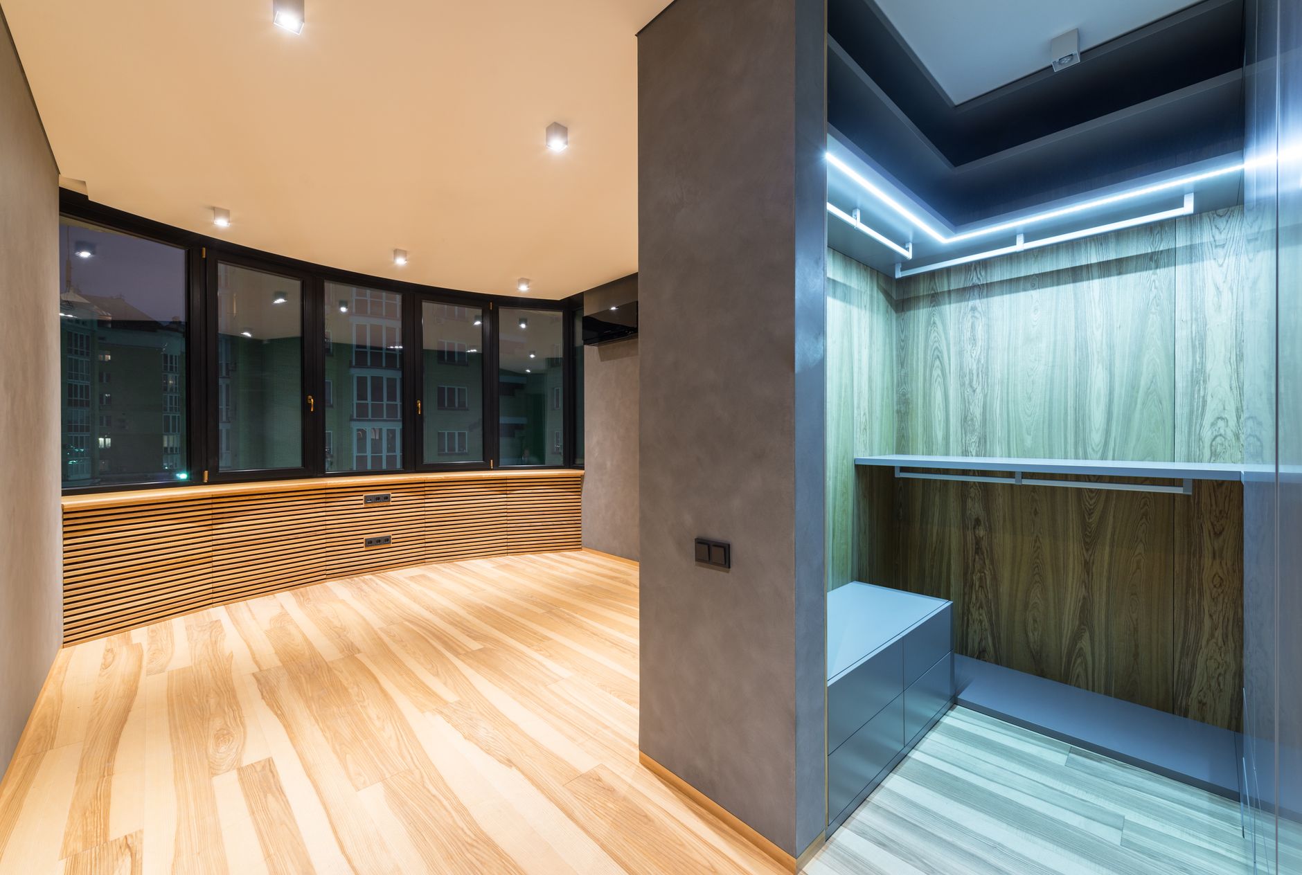 Creative design of empty room interior with wardrobe against windows under shiny lights in flat with parquet, illustrating What Does Feng Shui Say About a Top-Floor Flat