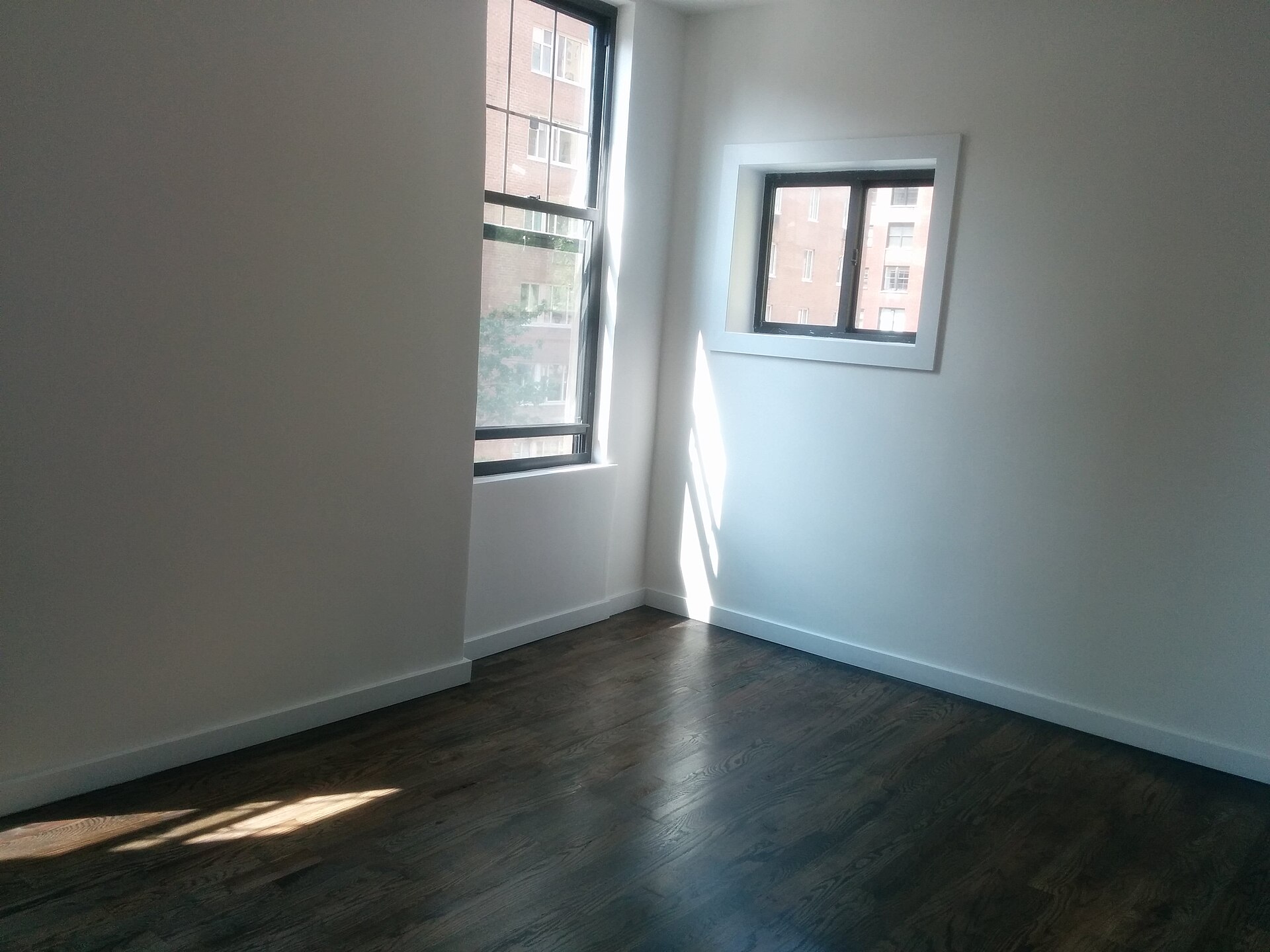 Empty apartment room with corner windows, illustrating What Does Feng Shui Say About a Top-Floor Flat