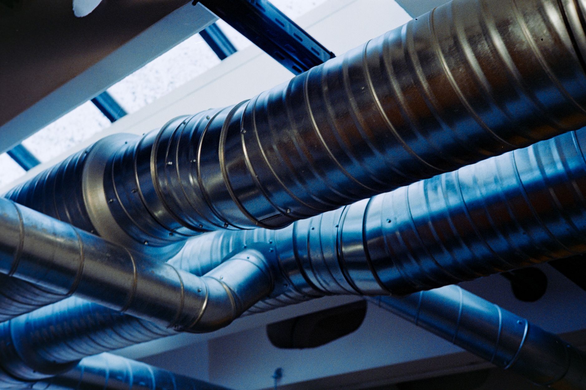 Close up of a modern metallic ventilation system in an industrial setting, illustrating What Does Feng Shui Say About Ventilation and Stale Air