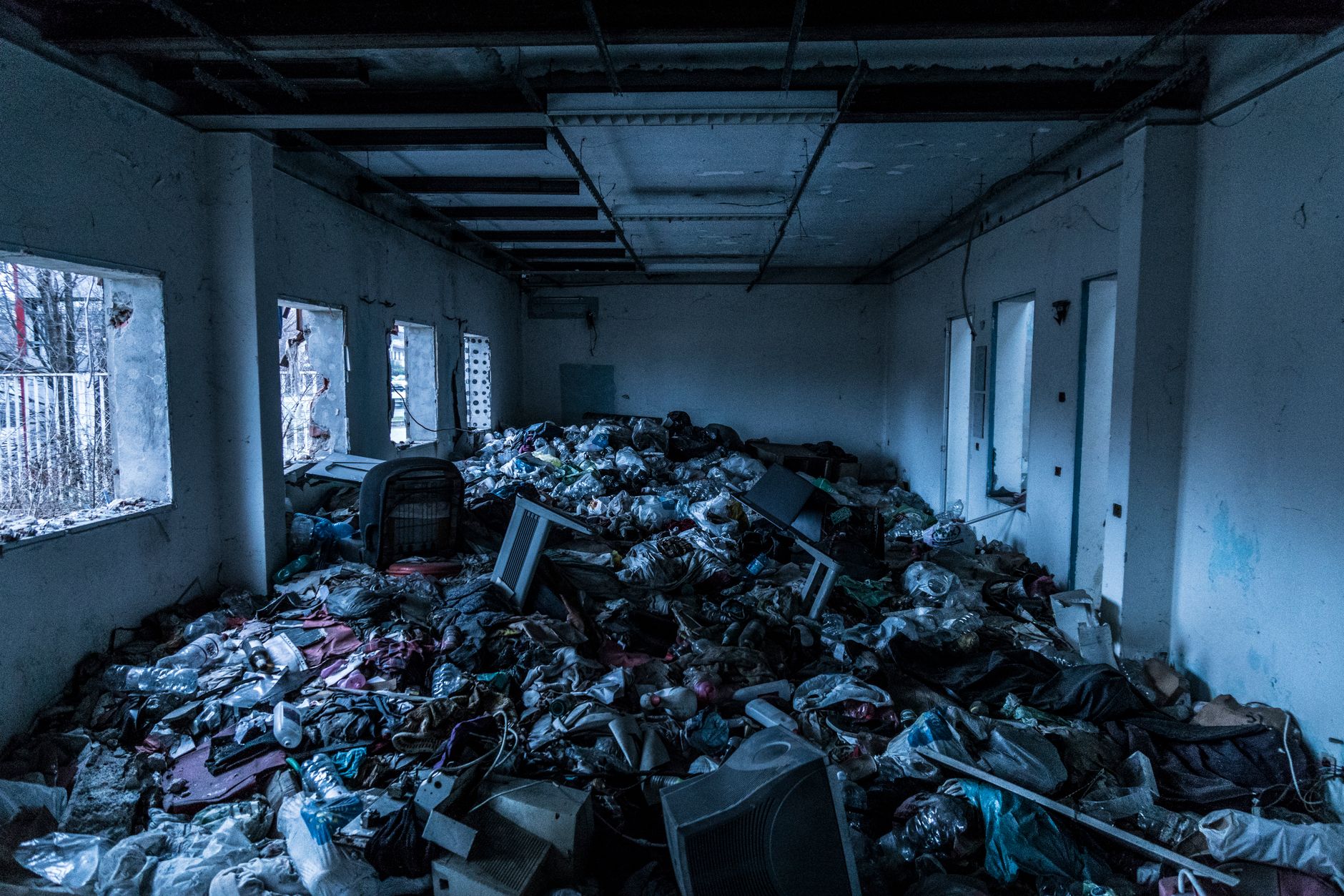 Interior of an abandoned building cluttered with trash and debris, creating a scene of decay and neglect, illustrating What to Ignore in Most Online Feng Shui Advice