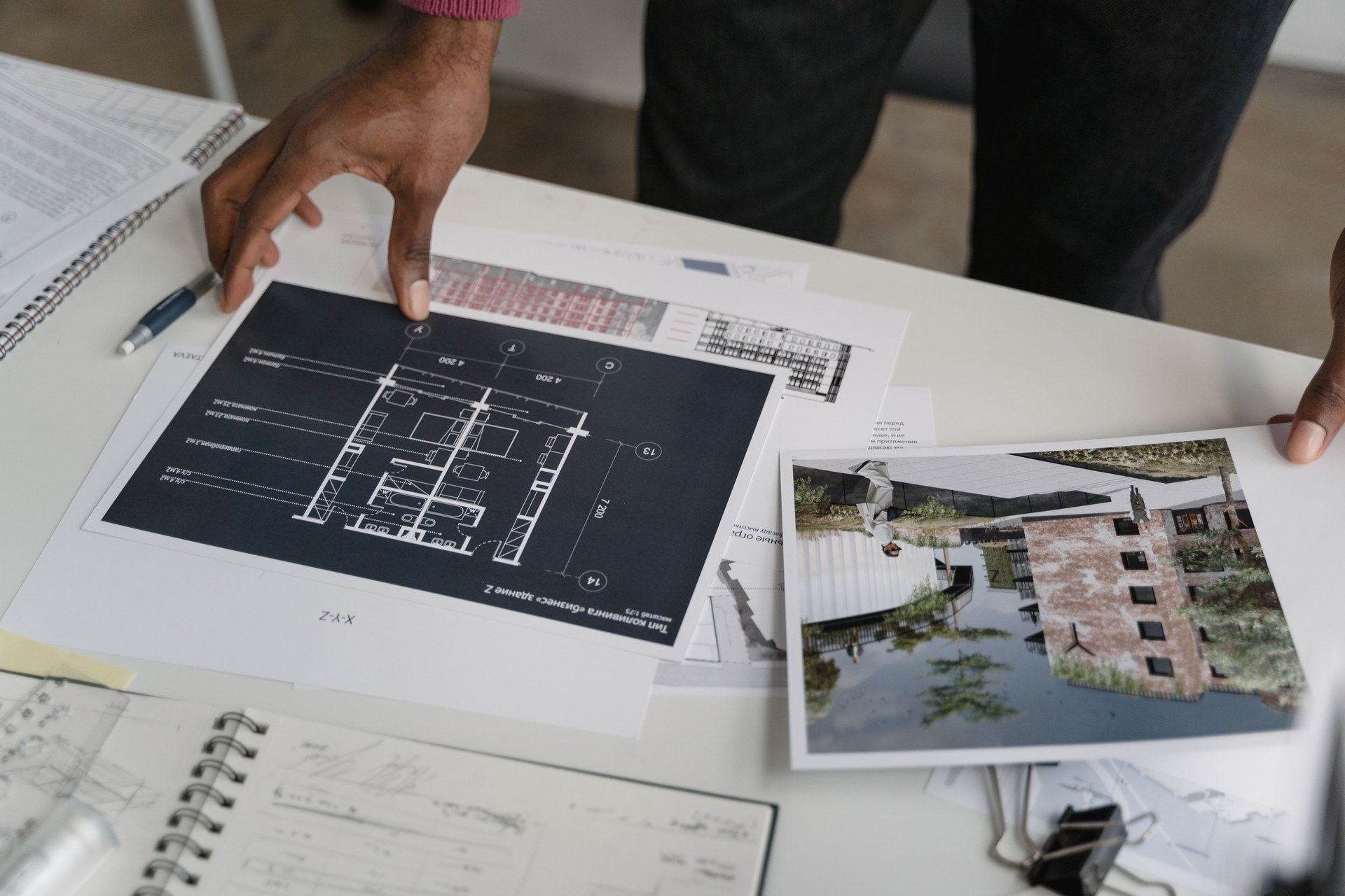 Architect hands reviewing architectural blueprints and design documents in an office setting