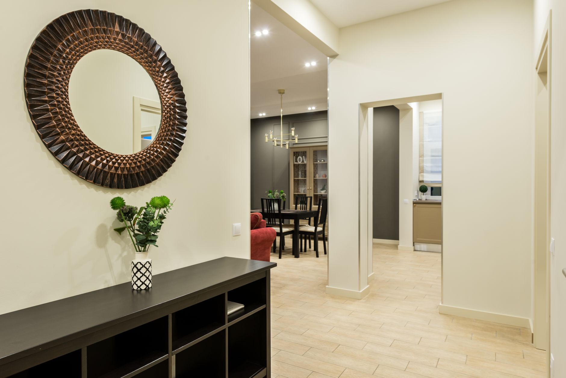 Interior of modern large flat with green plant on black shelf in hall illuminated with bright lamps, illustrating Why Does Feng Shui Object to a Cluttered Entrance