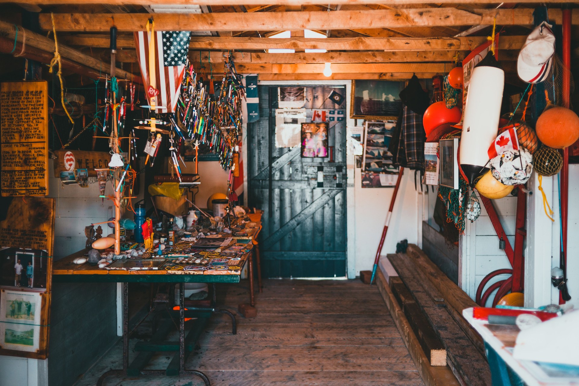 A cluttered workshop filled with various tools, decorations, and hanging flags creating a vibrant and busy atmosphere